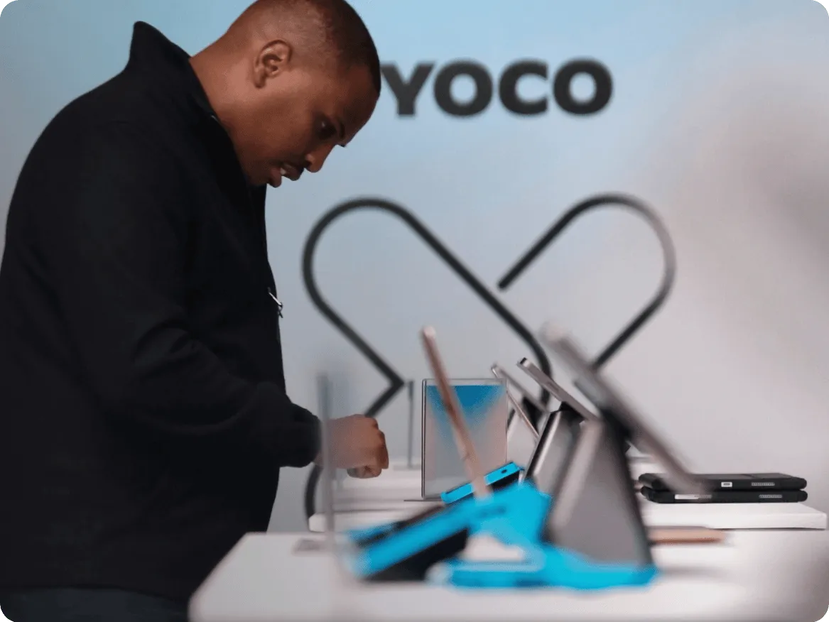 Yoco employee setting up point of sale devices on a counter.