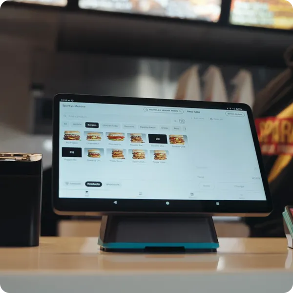 Yoco Counter POS system on a countertop showing a digital menu with burger options at a restaurant.