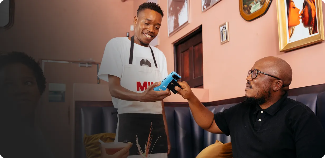A customer tapping a handheld pos to make a payment
