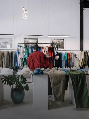 Customer browsing clothing racks in a modern retail store.