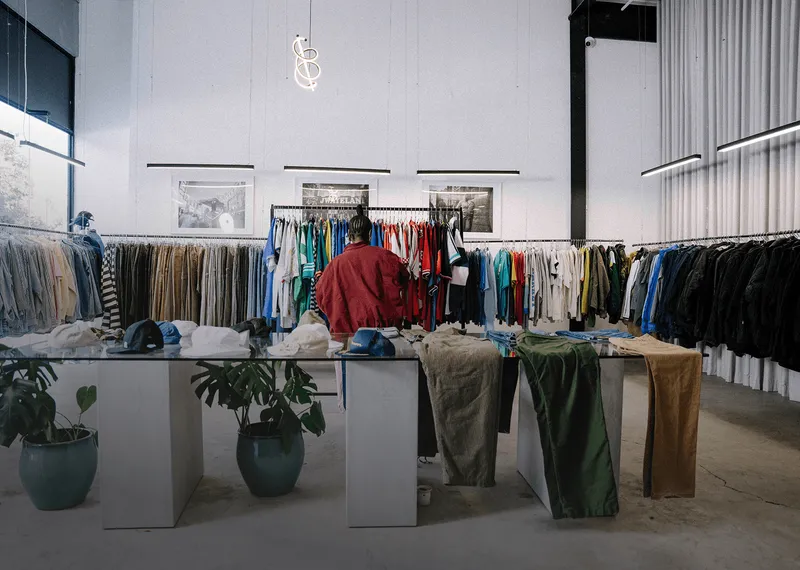Customer browsing clothing racks in a modern retail store.