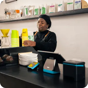 Collage showing Yoco POS systems in use across cafés and retail stores, including tablets, card machines, and payment screens.
