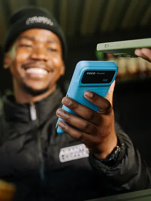 Merchant using a handheld POS device to accept a contactless payment.