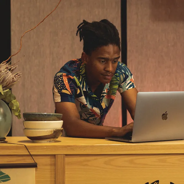 Retail business owner managing operations on a laptop at the counter
